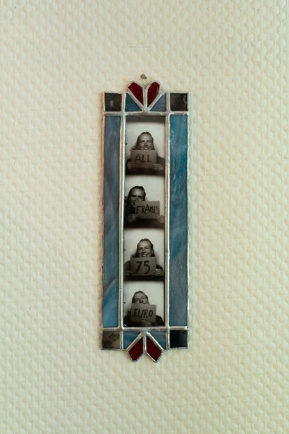 Decorative stained glass frame with four small portraits on a textured white background